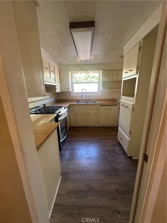 7918 Kyle St, Sunland, CA 91040 - kitchen featuring a sink, stainless steel range with gas stovetop, dark wood-style floors, under cabinet range hood, and white cabinets