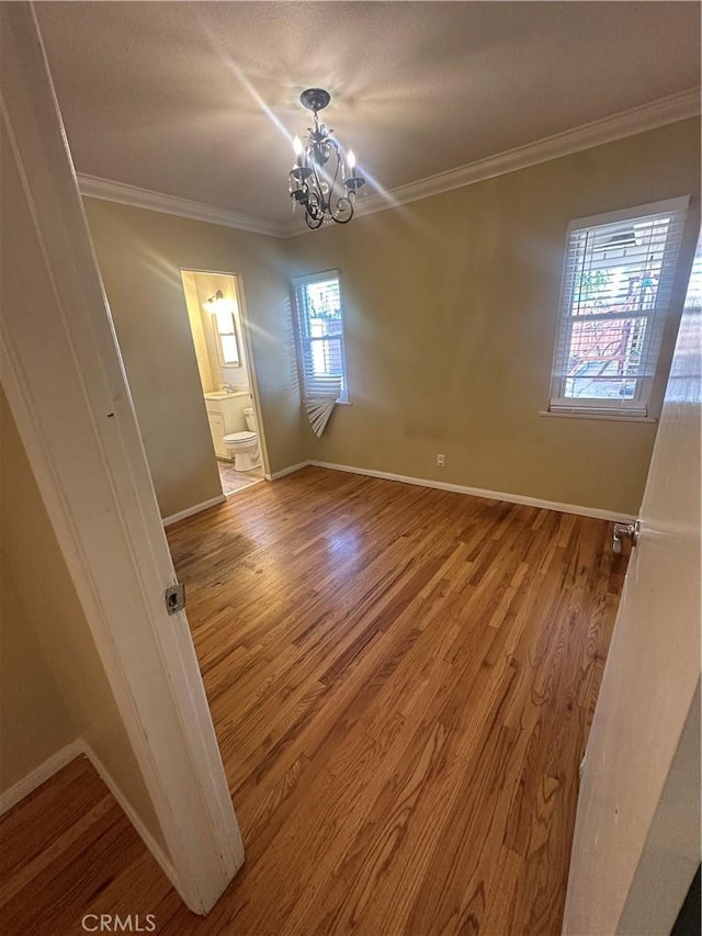 7918 Kyle St, Sunland, CA 91040 - spare room with a chandelier, plenty of natural light, ornamental molding, and wood finished floors