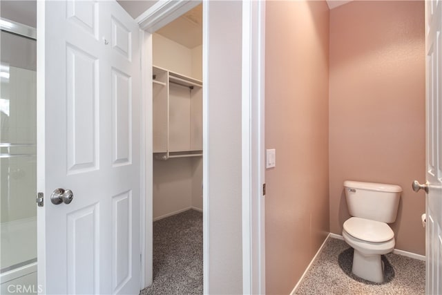 full bath featuring toilet, baseboards, an enclosed shower, and a spacious closet