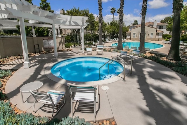 community pool with a pergola and a patio area