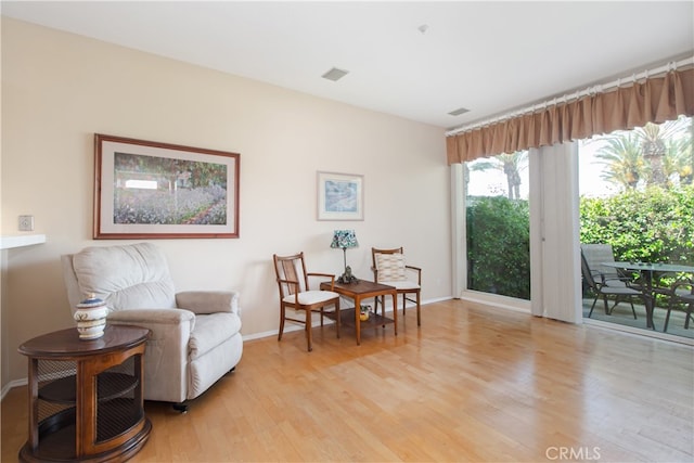 living area featuring light wood-style floors and baseboards