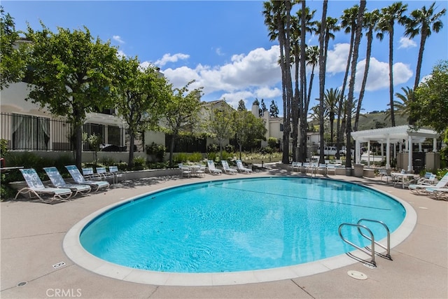 community pool with a patio and a pergola
