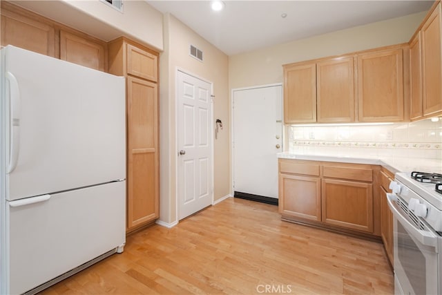 kitchen featuring white appliances, light brown cabinets, light countertops, decorative backsplash, and recessed lighting