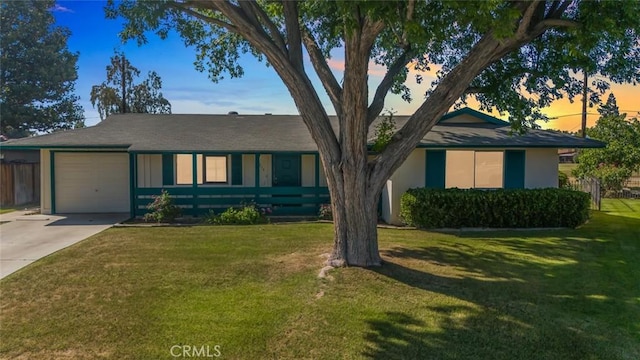 ranch-style home with a garage, concrete driveway, and a lawn