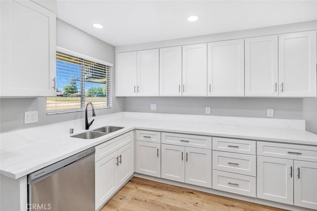 kitchen with stainless steel dishwasher, a sink, white cabinetry, light wood-style flooring, and recessed lighting