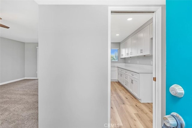 hallway with recessed lighting, light wood-type flooring, and baseboards