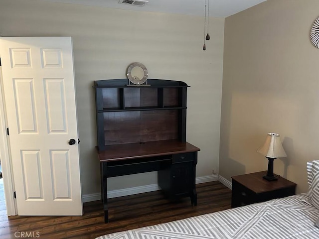 bedroom with wood finished floors and baseboards