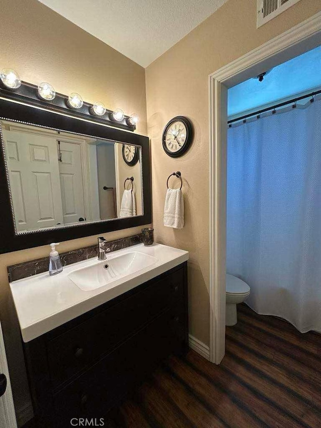 full bathroom featuring wood finished floors, vanity, toilet, baseboards, and a shower with curtain