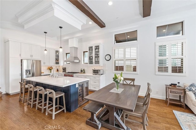 1715 Reed St, Redondo Beach, CA 90278 - kitchen with a kitchen bar, backsplash, beam ceiling, light wood-type flooring, and glass insert cabinets