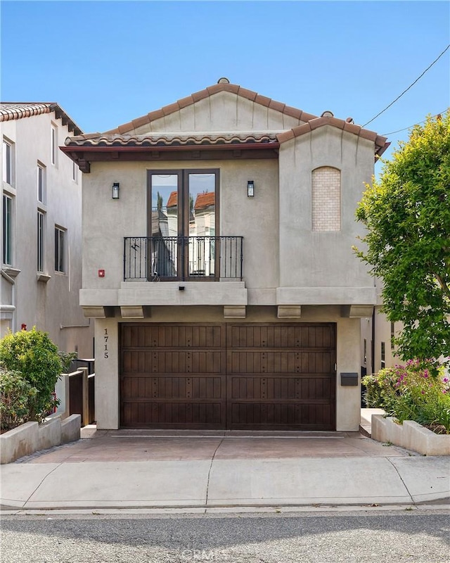 1715 Reed St, Redondo Beach, CA 90278 - mediterranean / spanish-style home featuring a balcony, an attached garage, a tile roof, driveway, and stucco siding