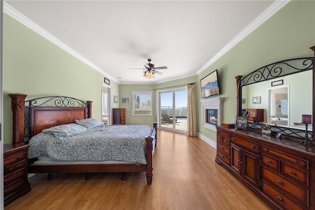40267 Scanlon Rd, Temecula, CA 92592 - bedroom featuring access to outside, a glass covered fireplace, crown molding, light wood finished floors, and baseboards