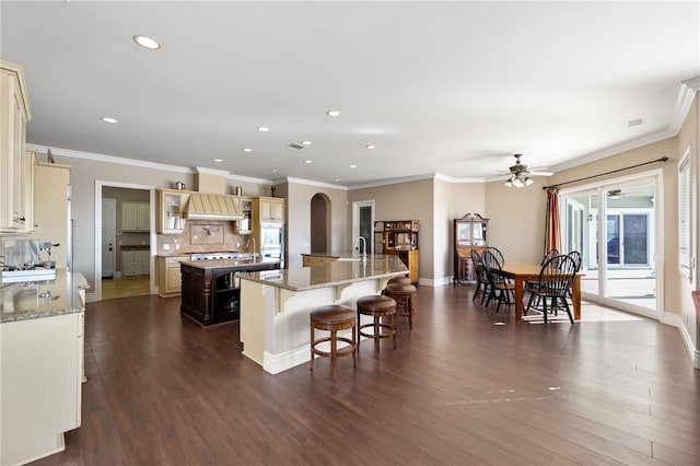 40267 Scanlon Rd, Temecula, CA 92592 - kitchen with a large island with sink, ceiling fan, recessed lighting, arched walkways, and dark wood-style flooring