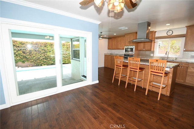 5309 Emerald St, Torrance, CA 90503 - kitchen with exhaust hood, stainless steel appliances, a ceiling fan, brown cabinets, and crown molding
