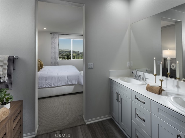 35232 Lopez Ln, Beaumont, CA 92223 - bathroom with wood finished floors, connected bathroom, double vanity, and baseboards