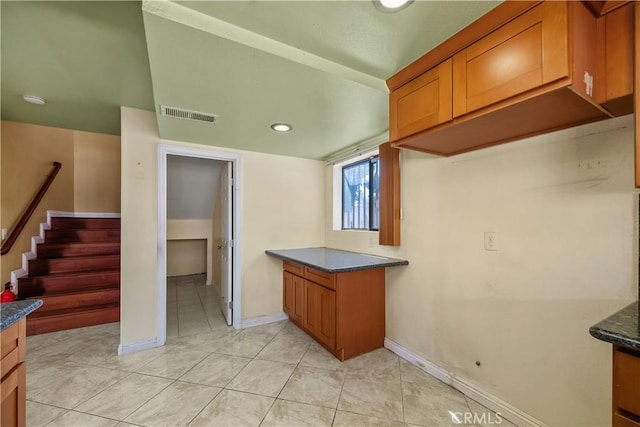kitchen with brown cabinetry, light tile patterned flooring, baseboards, and recessed lighting