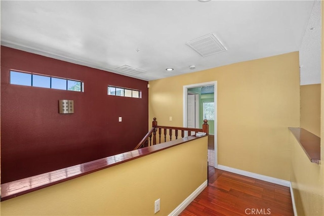 hall featuring an upstairs landing, wood finished floors, and baseboards