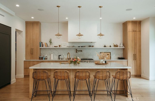 10 Seabluff, Newport Beach, CA 92660 - kitchen featuring open shelves, backsplash, recessed lighting, light wood-style floors, and a large island