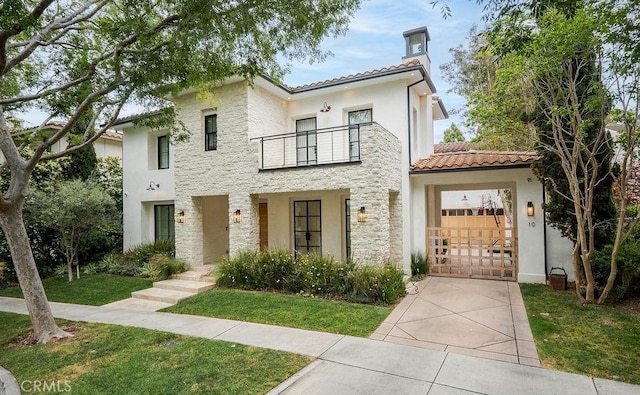 10 Seabluff, Newport Beach, CA 92660 - view of front of house with a balcony, a tiled roof, stucco siding, stone siding, and a front lawn