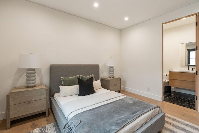10 Seabluff, Newport Beach, CA 92660 - bedroom featuring wood finished floors, recessed lighting, a sink, baseboards, and ensuite bath