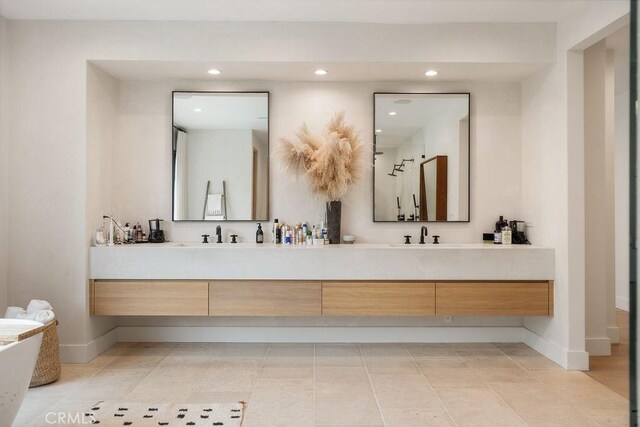 10 Seabluff, Newport Beach, CA 92660 - bathroom with double vanity, recessed lighting, baseboards, and a soaking tub
