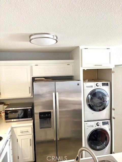 15000 Downey Ave Unit 273, Paramount, CA 90723 - laundry room featuring stacked washer and clothes dryer and a textured ceiling