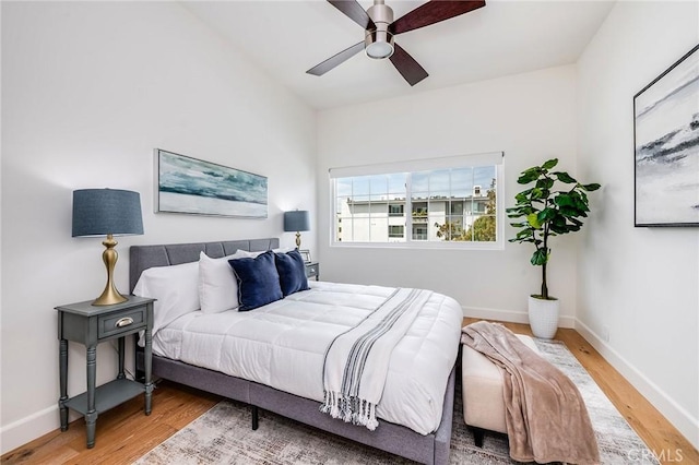 bedroom featuring wood finished floors, baseboards, and ceiling fan