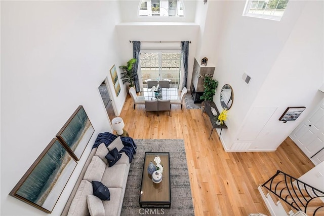 living room with wood finished floors and a towering ceiling