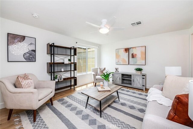 living area with wood finished floors, ceiling fan, and baseboards