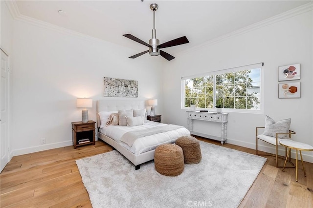 bedroom featuring ornamental molding, light wood finished floors, baseboards, and a ceiling fan