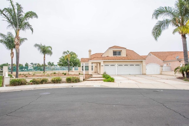 28679 Corte Capri, Menifee, CA 92584 - mediterranean / spanish-style house with a garage, stucco siding, concrete driveway, a tiled roof, and a chimney