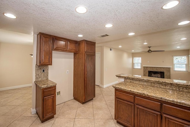 28679 Corte Capri, Menifee, CA 92584 - kitchen with a ceiling fan, a fireplace, light tile patterned floors, stone counters, and recessed lighting