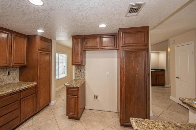 28679 Corte Capri, Menifee, CA 92584 - kitchen with decorative backsplash, light tile patterned flooring, brown cabinetry, recessed lighting, and a textured ceiling