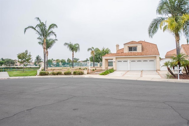 28679 Corte Capri, Menifee, CA 92584 - mediterranean / spanish-style home featuring driveway, stucco siding, an attached garage, and a chimney
