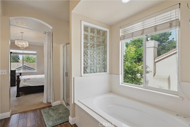 1958 Fall Brook Ct, Merced, CA 95340 - bathroom with wood finished floors, a garden tub, a shower stall, connected bathroom, and baseboards