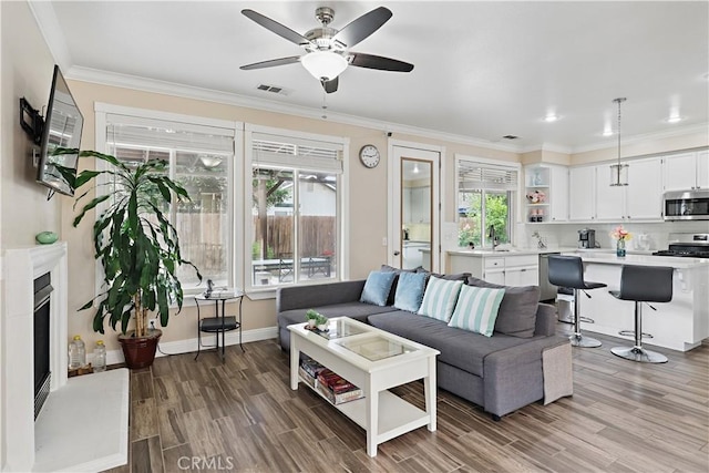 1958 Fall Brook Ct, Merced, CA 95340 - living area featuring wood finished floors, a ceiling fan, ornamental molding, and baseboards