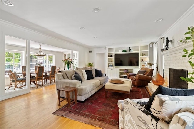 5132 Quakertown Ave, Woodland Hills, CA 91364 - living room with crown molding, light wood-type flooring, a brick fireplace, built in shelves, and recessed lighting