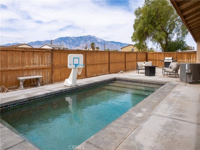 66659 El Dorado Pl, Desert Hot Springs, CA 92240 - view of swimming pool with a mountain view, a patio area, a fenced backyard, and an outdoor living space