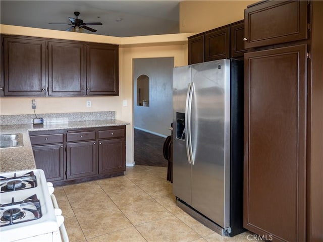66659 El Dorado Pl, Desert Hot Springs, CA 92240 - kitchen with stainless steel fridge with ice dispenser, a ceiling fan, dark brown cabinets, stove, and light tile patterned floors