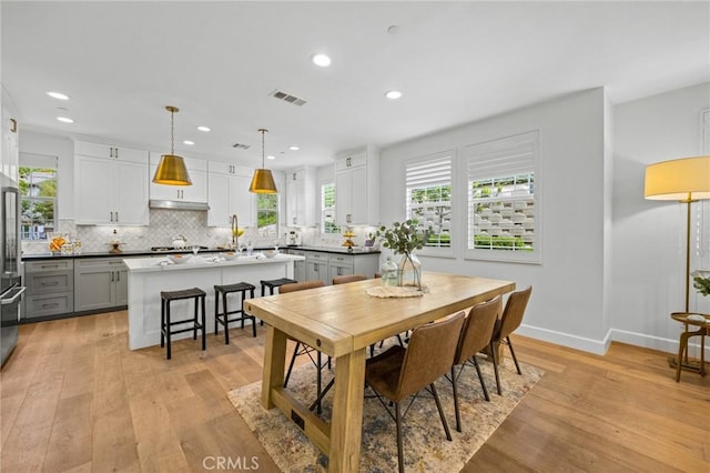 dining space featuring light wood-style flooring, recessed lighting, and baseboards