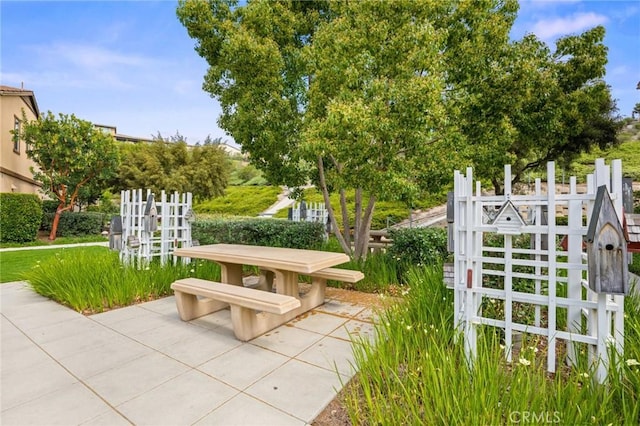 view of property's community featuring fence and a patio area