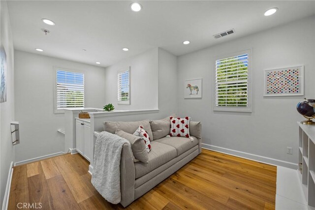 living area with light wood finished floors, baseboards, and recessed lighting