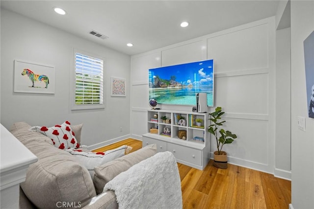 living room featuring wood finished floors, recessed lighting, and baseboards