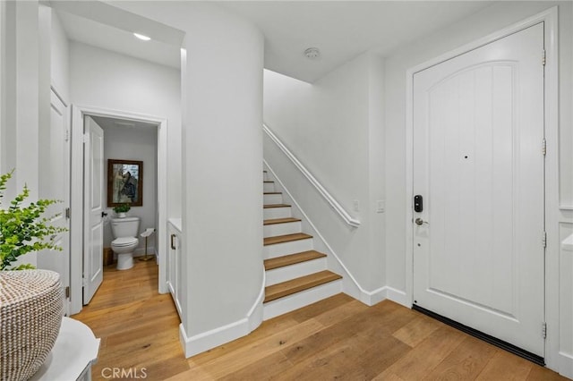 foyer featuring light wood-style flooring, stairs, and recessed lighting