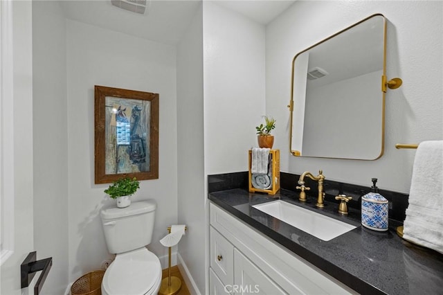 half bathroom featuring vanity and toilet