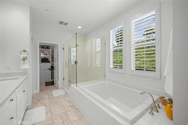 full bath featuring a stall shower, a spacious closet, a bath, vanity, and marble finish floors