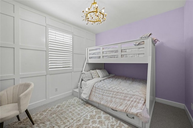 bedroom featuring a chandelier, carpet, baseboards, and a decorative wall