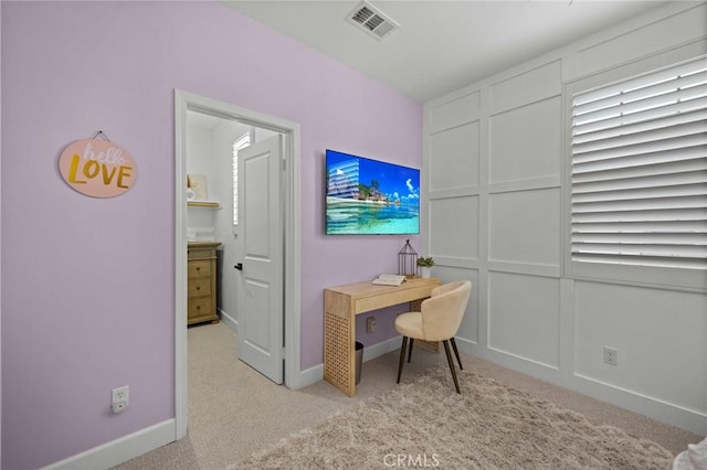 office area featuring light carpet and baseboards