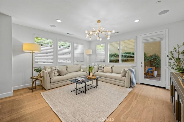 living room featuring light wood-style flooring, a chandelier, baseboards, and recessed lighting