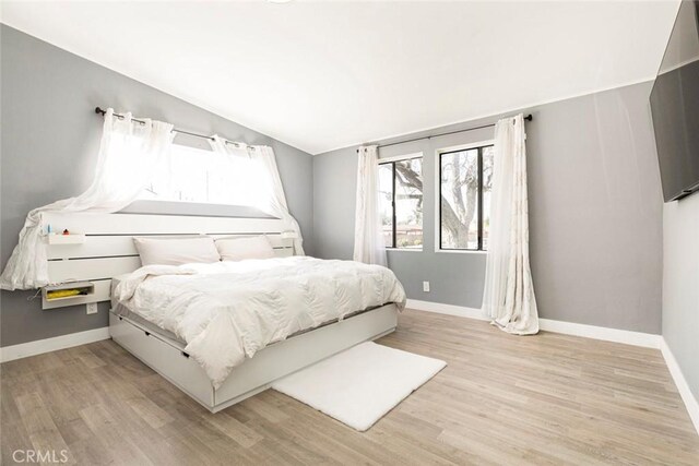 7700 Goodland Ave, North Hollywood, CA 91605 - bedroom featuring vaulted ceiling, baseboards, and light wood finished floors