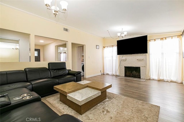7700 Goodland Ave, North Hollywood, CA 91605 - living room with a chandelier, wood finished floors, healthy amount of natural light, a fireplace, and crown molding
